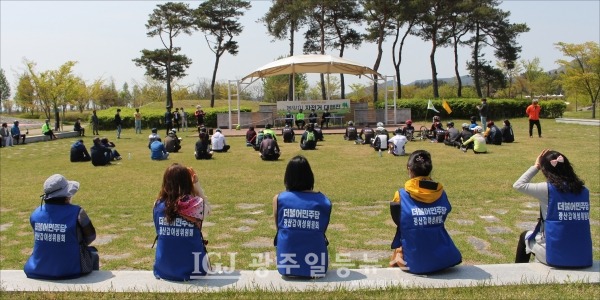 승촌보 영산강 문화관 뒷편 보조운동장에서 열린 행사에서 봄볕에 앉아 경청을 하는 광산구갑지역위 여성위원들 모습.