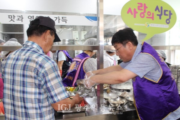정재봉 광산구의회 행정자치위원장이 뜨거운 삼계탕을 식판에 올려 드리고 있다.