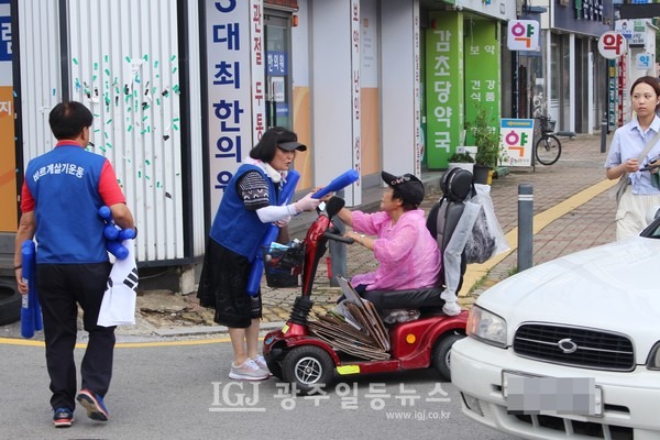 광산구협의회 김열화 부회장이 길가는 시민에게 태극기를 나눠주고 있다.